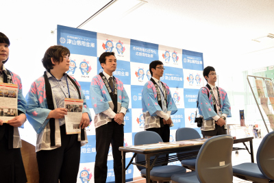 写真：津山信用金庫職員が5人並んでたつ。入学式での相談窓口の様子