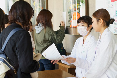 写真：実習食堂の外で受付をする学生