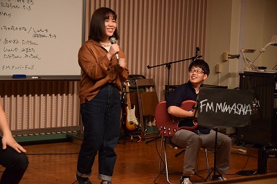 ステージで楽器を演奏し歌う学生