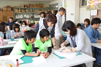 写真：仕掛けの作り方を子どもたちにレクチャーする学生