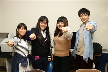 写真：児童文化研究部の広報チームの4名がガッツポーズをする写真