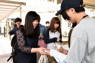 写真：買い物をする学生。商品を渡す社会福祉学科の学生