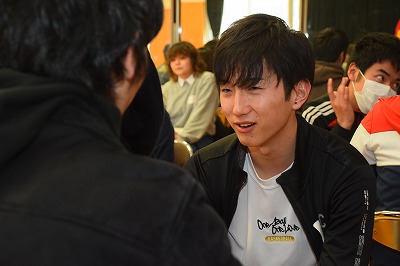 写真：午後からのセミナーの様子。2人組になって話をする学生