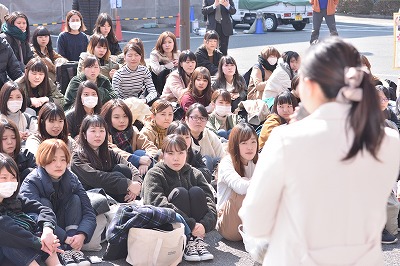 写真：激励をする教員。聞き入る学生