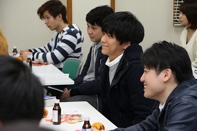 写真：教員の話に笑みを浮かべる学生