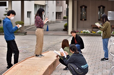 写真：スロープの勾配を計算するために必要な部分の寸法を図る学生たち