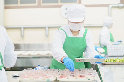 写真：調理担当の学生が丁寧に盛り付ける様子