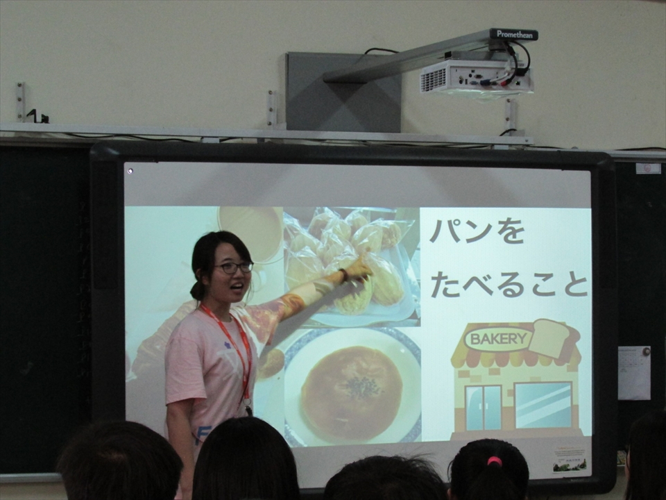 写真：スライドに映し出されたものについて説明する大学生