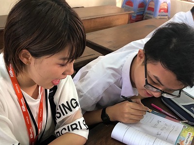 ベトナムの学生と机について話をしている様子
