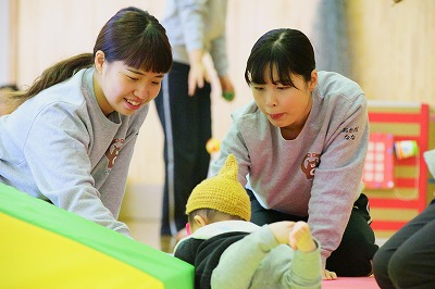 写真：子どもと遊ぶ学生