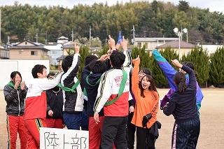 写真：全員で人差し指を上に掲げる陸上部チーム