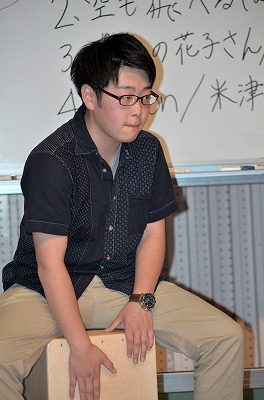 写真：カホンを叩いてリズムを刻む学生1人