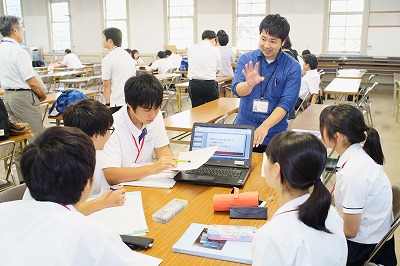 写真：グループワークをする高校生とアドバイスする