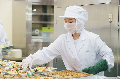 写真：調理担当の学生が丁寧に盛り付ける様子