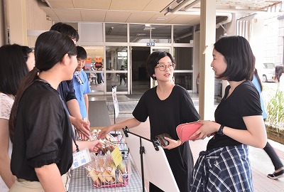 写真：どれを買うか迷っている学生2名