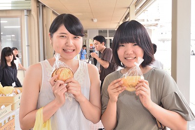 写真：買ったものを見せてくれる学生2名