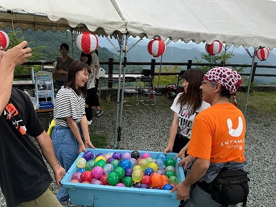 写真：水風船が入ったケースを一緒に運ぶスタッフ