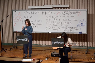 写真：ステージ上で歌とギターを披露する学生2人