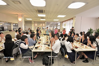 写真：昼食会場でいただきますをする学生スタッフ