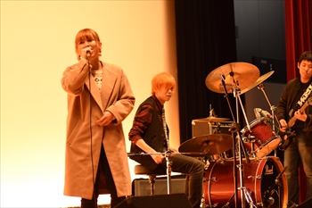 写真：マイクを握って歌う軽音部の学生