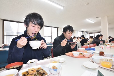 写真：提供された食事をおいしそうに食べる学生たち