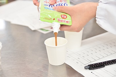 写真：治療用食品を紙コップに注ぐ