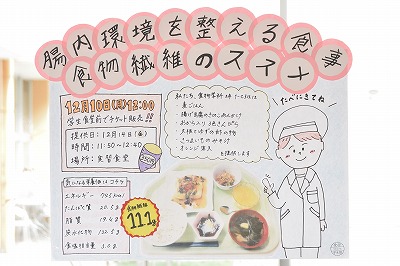 写真：学内で給食経営管理論実習02の告知をするポスター。