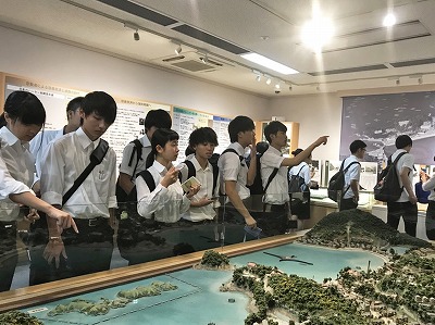 写真：ジオラマで周辺の環境や島全体の様子を見る学生たち