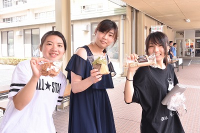 写真：買ったものを見せてくれる学生3名