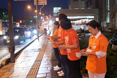 写真：街頭で啓発チラシやパンフレットを配布する学生と堀川先生