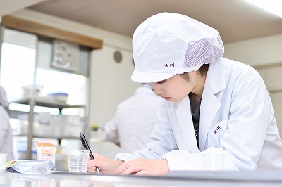 写真：メモを取りながら試食や実習をする学生