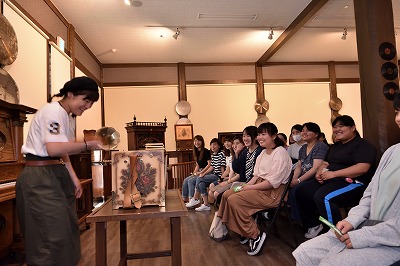 写真：手回しオルゴールを回す学生