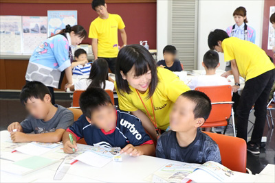 写真：金の基礎知識を学ぶ授業で、小学生の質問に寄り添いながら答える学生