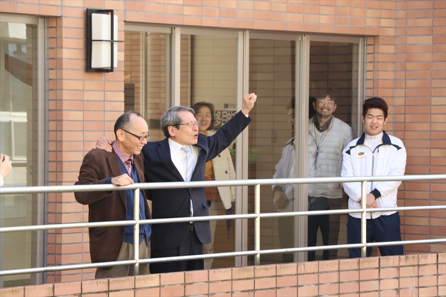写真：肩を組んでこぶしを突き上げる2名の先生