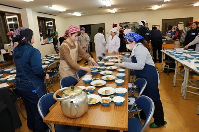 写真：テーブルに配膳する学生たち