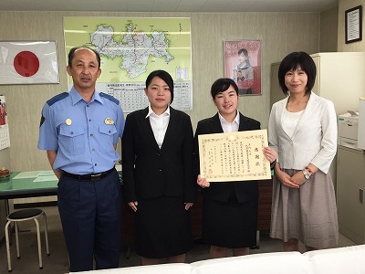 写真：感謝状を手に記念撮影する学生2名、教員1名と署長