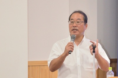 写真：指を折って事例等を説明する岸本氏