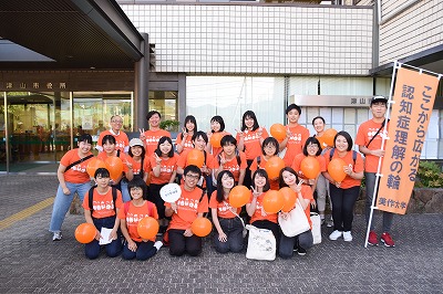 オレンジ色のTシャツを着て啓発活動をする様子