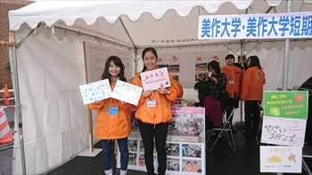 写真：ブースの前でプラカードを持つ学生
