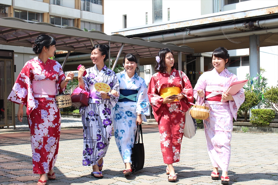 写真：浴衣を着た女子学生5名が談笑をしながら中庭を歩く様子