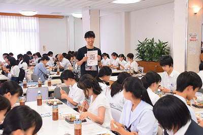 写真：昼食の学生開発の食育弁当の説明をする学生