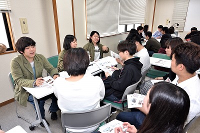 写真：熱心に研究室活動について説明する4年生3人と熱心に聞き入る3年生の後姿