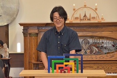 写真：積み木遊びの実演をする橋爪館長