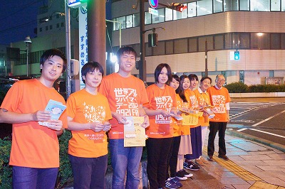 写真：オレンジ色のティーシャツを着て、記念撮影