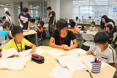 写真：楽しそうに小学生２名に指導する女子学生