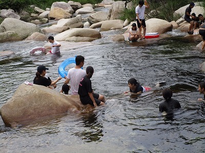 子ども達と川遊びをする部員達