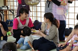 写真：蒸しパンを配る学生と受け取る保護者