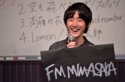 写真：曲と曲の間にMCをする学生1人