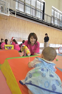 写真:遊具やおもちゃを使って子どもと遊ぶ学生
