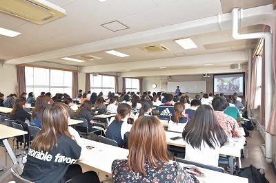 写真：講師の話を聞く学生たち。後ろから